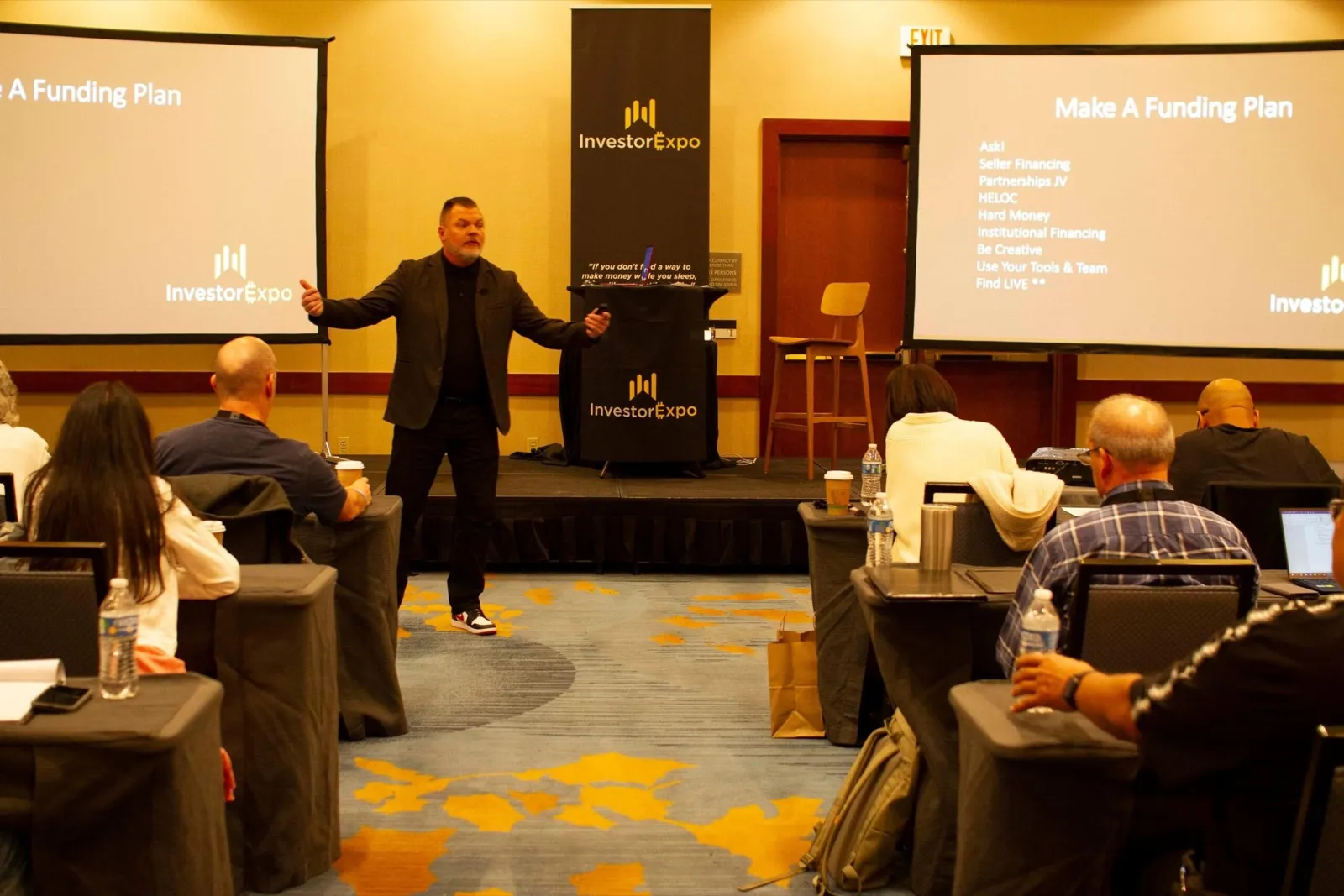 Presenter on stage at the Tax Lien Wealth Builders Investor Expo discussing funding plans