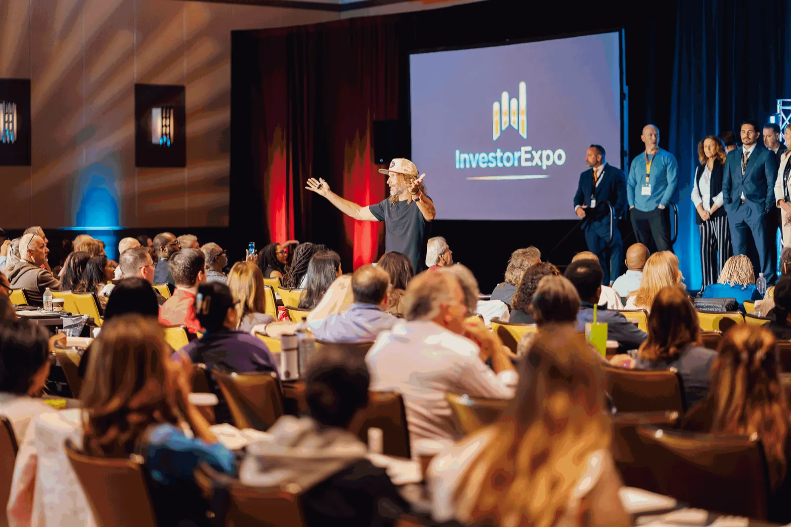 Speaker on stage addressing a packed audience at the Tax Lien Wealth Builders Investor Expo